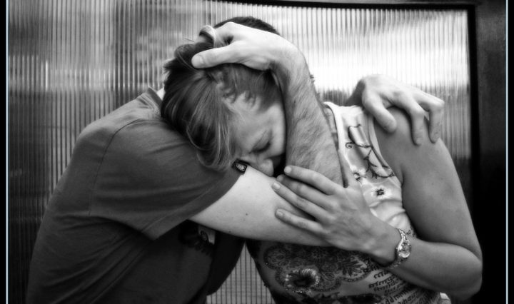 two people upset and embracing each other