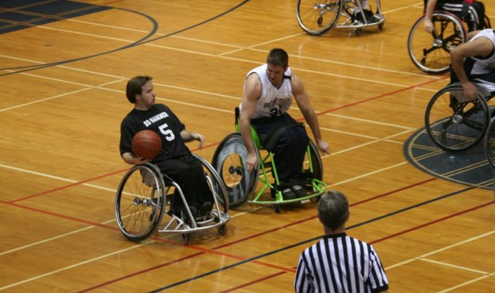 two men in wheelchairs playing basketball