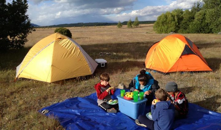 two tents and a family enjoying a camping holiday