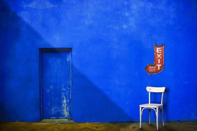 azure wall with a white chair against it